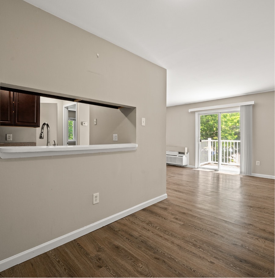 vinyl floored dining/living area with pass-through to kitchen and patio door